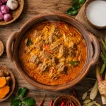 Gulai daging sapi dalam kuali tanah liat dengan kuah santan kental berwarna merah kekuningan serta rempah segar di sekelilingnya