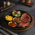 Meltique ribeye steak panggang dengan saus creamy, jagung, jamur, dan salad segar.